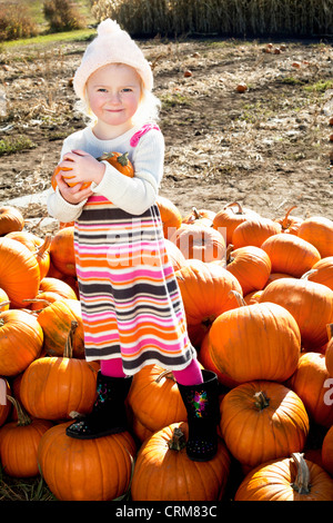 Portrait d'une jeune fille debout sur pumpkin Banque D'Images