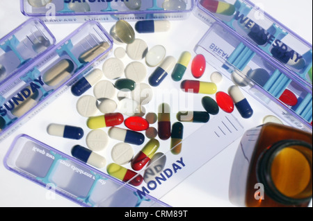 Un assortiment de comprimés et gélules multicolores entouré par les boîtes de pilulier. Banque D'Images