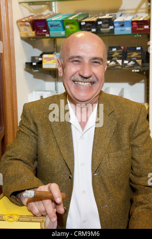 Portrait of a mature propriétaire de magasin de tabac smoking cigar Banque D'Images