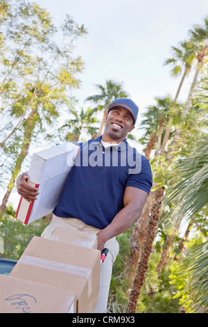 Low angle view of a happy homme livraison de colis Banque D'Images
