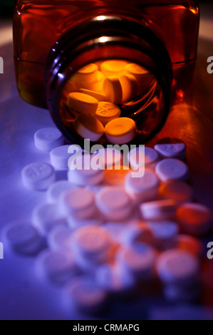 Comprimés blancs déversement provenant d'un flacon de médicaments. Banque D'Images