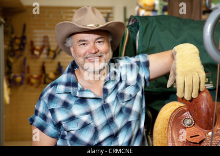 Portrait of a mature cowboy dans magasin de fourrage Banque D'Images