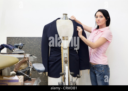 Portrait of a Mid adult woman dressing mannequin Banque D'Images