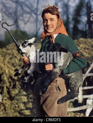 Un women's land army girl holding un agneau nouveau-né. 1939-45. Banque D'Images