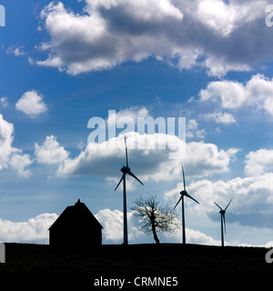 Silhouette d'une ferme, d'éoliennes et d'un arbre. Cezallier. L'Auvergne. La France. L'Europe. Banque D'Images