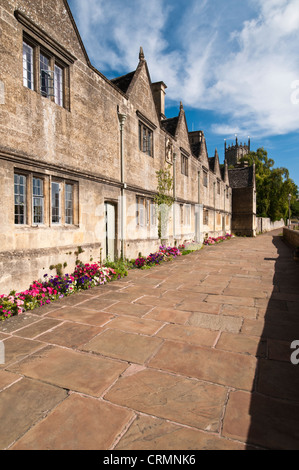 Rangée d'hospices à côté d'un large chemin dallé et St James' Church tout juste visible, à Chipping Campden, Cotswolds, Gloucestershire, Angleterre Banque D'Images