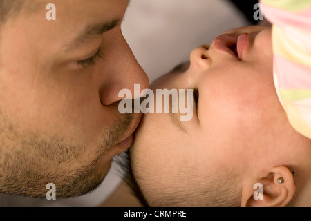 Un père s'embrasser son bébé sur la tête. Banque D'Images