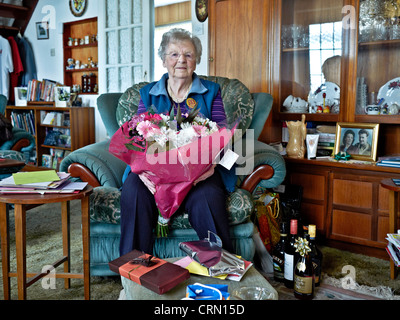 La haute vieille de 90 ans à la maison pour son anniversaire entouré de cadeaux. Europe Royaume-Uni Angleterre Banque D'Images