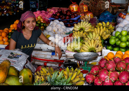 Vendeur de fruits portant krama (écharpe cambodgienne traditionnelle) exposition de fruits en plein air avec bananes, fruits et pommes du dragon, Siem Reap, Cambodge. © Kraig Lieb Banque D'Images