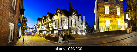 Une vue panoramique de personnes boire et manger à l'extérieur de l'ancienne maison de tisserands sur la rue principale à Canterbury. Banque D'Images