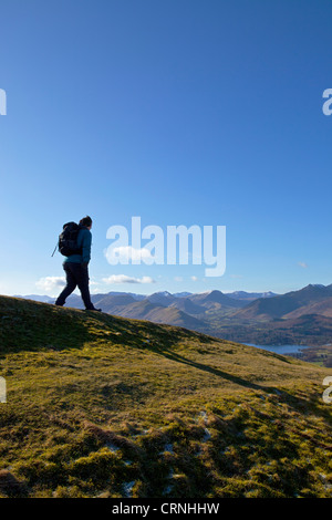 Walker en ordre décroissant une crête dans le Parc National du Lake District. Banque D'Images