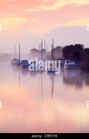 Brume matinale de petits bateaux de plaisance amarrés sur la rivière Frome à Wareham Quay. Banque D'Images