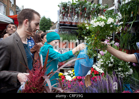 Les acheteurs et les vendeurs à l'Est de Londres dimanche du célèbre marché aux fleurs sur le Columbia Road. Banque D'Images