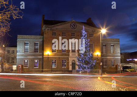 Un grand sapin de Noël décoré avec des lumières à l'avant de la maison du marché dans le centre-ville de Taunton. Banque D'Images