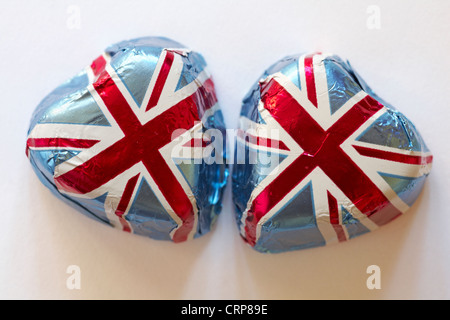 Deux chocolats en forme de cœur enveloppé dans Union Jack aluminium isolé sur fond blanc Banque D'Images