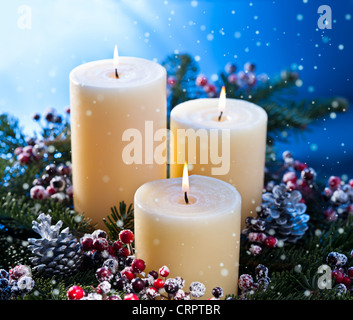 Trois chandelles dans un arrangement floral de l'avent pour l'avent et Noël avec chutes de neige Banque D'Images