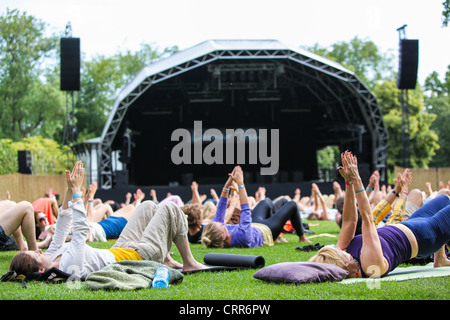 Yoga tôt le matin en face de la scène principale au festival de musique 2011 Larmer Tree, UK Banque D'Images