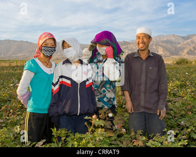 Une famille chinoise ouïghoure coton cueillette de leur champ pose devant l'appareil photo. Banque D'Images