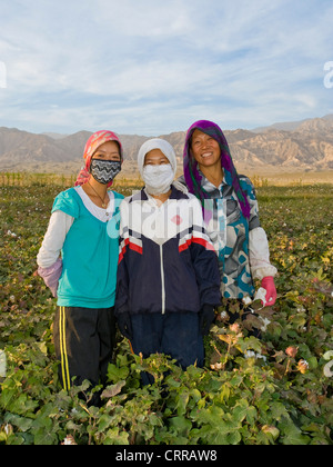 Une famille chinoise ouïghoure coton cueillette de leur champ pose devant l'appareil photo. Banque D'Images