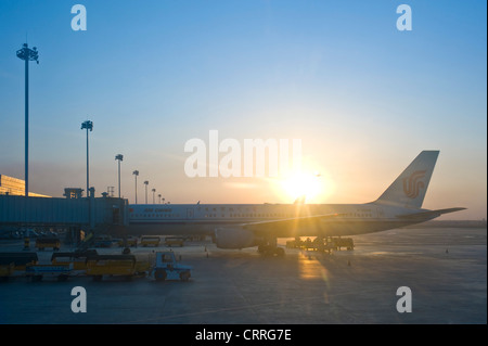 Un avion d'Air China sur le stand au coucher du soleil à la borne 3 de l'aéroport d'Urumqi. Banque D'Images