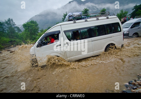 Un mini bus traverse une partie de la route sur l'autoroute entre Pokhara et Katmandou, Népal. Banque D'Images