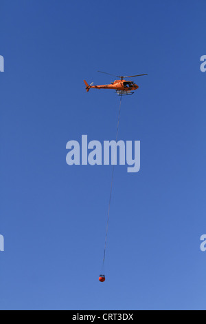 Un hélicoptère du Service forestier des États-Unis transporte l'eau d'un incendie de forêt près de Bonner, Montana, USA Banque D'Images