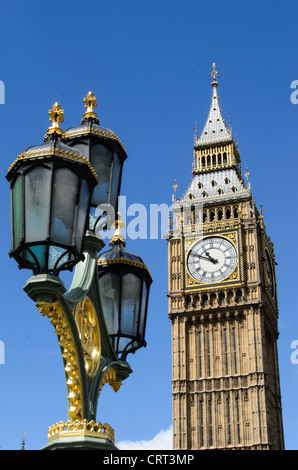 Elizabeth Tower Big Ben Westminster Bridge Lampe Londres | LONDRES — Un lampadaire en fonte doré et vert sur le pont de Westminster se dresse à côté de l'Elizabeth Tower, dont la maçonnerie néo-gothique a été conçue par Augustus Pugin dans le cadre du Palais de Westminster reconstruit par Charles Barry. Les lampes ornementales du pont, installées lors de l'ouverture de l'actuel passage en 1862, ont été conçues pour faire écho au langage décoratif des bâtiments du parlement auxquels elles font face. Banque D'Images