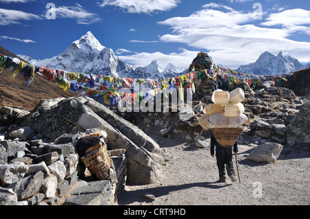 Porter népalais fait son chemin vers le bas les Thokla Pass dans la région de l'Everest Népal Banque D'Images