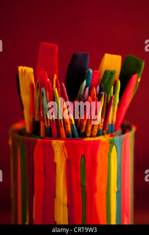 Pinceaux multicolores dans un pot recouvert de gouttes de peinture Banque D'Images