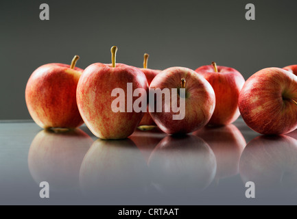 Pommes rouges sur la surface réfléchissante. Banque D'Images