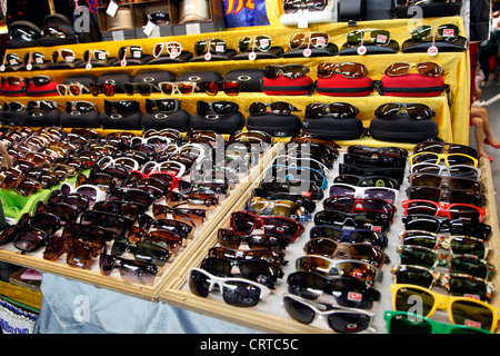 La vente de marchandises contrefaites et lunettes de designer sur un étal au marché nocturne de Patpong à Bangkok, Thaïlande. Banque D'Images