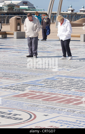 L'homme et la femme à la comédie au tapis sur la promenade de Blackpool. Banque D'Images