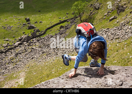 Un rock scrambler fixant l'ascension de la crête. Les lapins foulèrent rock scramble sur Knotts gris dans le Lake District, UK. Banque D'Images