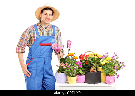 Un male florist posant à côté de fleurs isolé sur fond blanc Banque D'Images