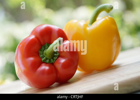 Poivrons verts, et poivron jaune on cutting board Banque D'Images