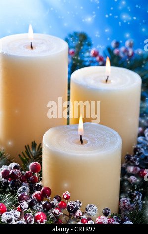 Trois chandelles dans un arrangement floral de l'avent pour l'avent et Noël avec chutes de neige Banque D'Images