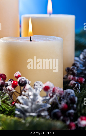 Trois bougies allumées dans un arrangement floral de l'avent pour l'Avent et de Noël une belle close up shoot Banque D'Images