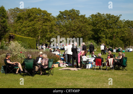 Les personnes ayant un pique-nique sur le gazon à l'opéra de Glyndebourne Festival, Lewes, dans le Sussex UK Banque D'Images