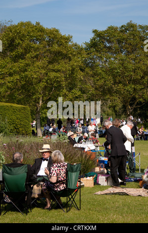 Les personnes ayant un pique-nique sur le gazon à l'opéra de Glyndebourne Festival, Lewes, dans le Sussex UK Banque D'Images