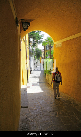 Une touriste marche à travers les rues étroites de Varenna Lac de Côme Italie Région Lombardie Banque D'Images