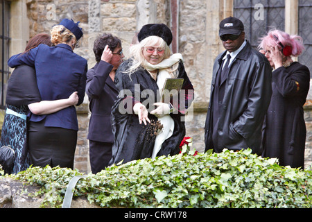 Dwina Gibb (centre), épouse de Robin Gibb, jette de la terre sur le cercueil lors des funérailles de la chanteuse Gee Bee. Banque D'Images