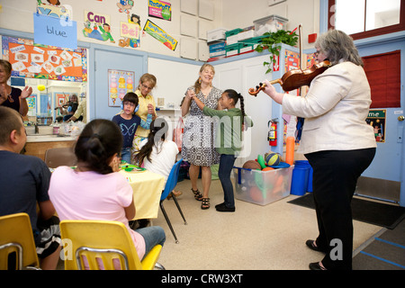 Célébration dans une classe d'éducation spéciale, aux États-Unis, les enseignants jouent de la musique et de la danse avec les élèves. Banque D'Images