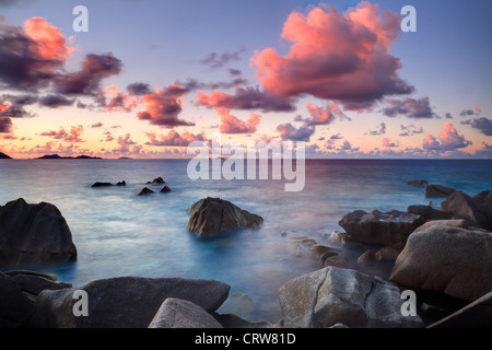 Nuages sur la Baie Ste Anne au coucher du soleil, vu de l'extrémité nord de la Digue aux Seychelles Banque D'Images