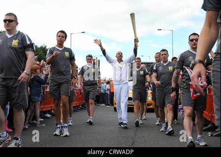 Agents de la Police métropolitaine entourent le porteur de flambeau olympique en passant par Coseley West Midlands Uk Banque D'Images