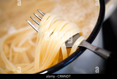 Les nouilles dans la casserole avec la fourchette Banque D'Images