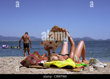 Une jeune femme sur la plage de lecture Banque D'Images