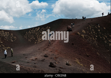 Touristes visitant les cratères de Silvestri près du Rifugio Sapienza à 1900m sur l'Etna, Sicile, Italie - la lave rouge est riche en fer Banque D'Images