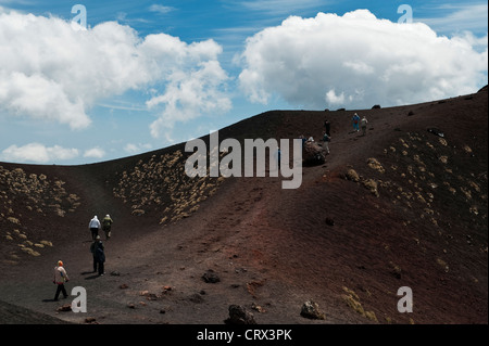 Touristes visitant les cratères de Silvestri près du Rifugio Sapienza à 1900m sur l'Etna, Sicile, Italie - la lave rouge est riche en fer Banque D'Images