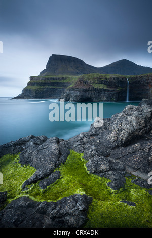 Côtes déchirées et chute d'eau à Gasadalur sur l'île de Vagar et, Îles Féroé. Printemps (juin) 2012. Banque D'Images