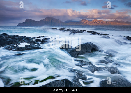 Les vagues se briser sur la montée des côtes rocheuses à mais confortables et disposent de l'île de Eysturoy, Îles Féroé. Printemps (juin) 2012. Banque D'Images